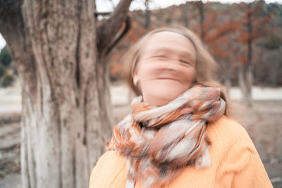 Close-up portrait of woman by tree trunk