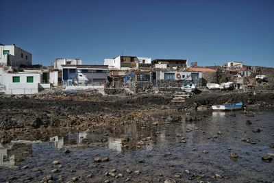 Buildings by river against clear blue sky. majanicho, fuerteventura, canary islands. 