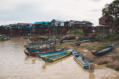 Boats moored on houses by buildings against sky