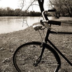 Bicycle by water against sky