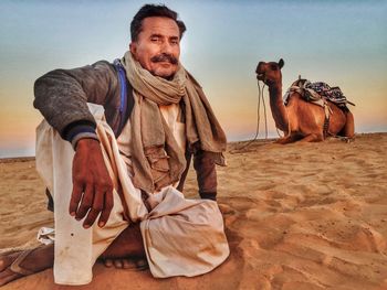 Full length of man sitting on sand