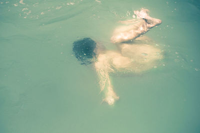 High angle view of naked man swimming in sea