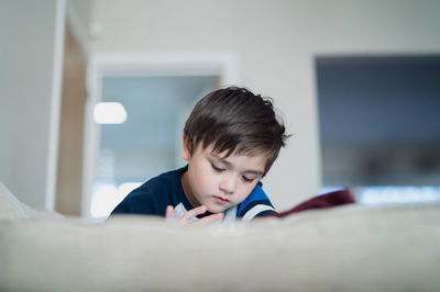 Cute boy lying on bed at home