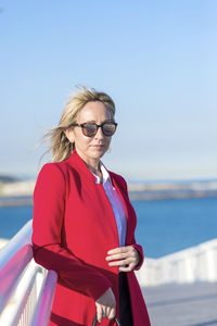 Portrait of young woman standing against sea