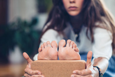 Young woman exercising with wooden block