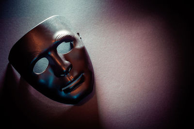 Close-up of mask on table against wall