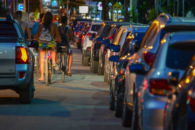 Rear view of people standing on street in city