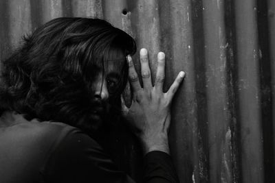 Side view of woman looking through window