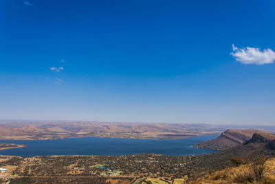 Scenic view of sea and mountains against blue sky