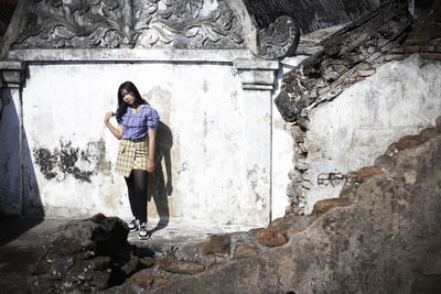 Portrait of man standing against wall