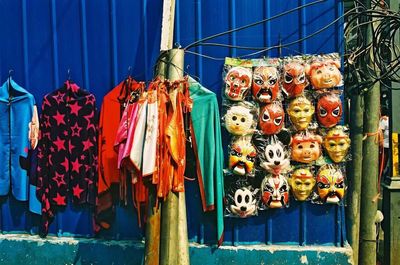 Clothes and mask hanging at market for sale