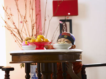 Close-up of boy picking food in container at table