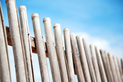 Low angle view of wooden fence against sky