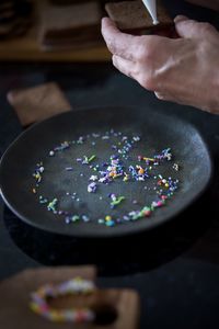 Cropped hand of woman decorating cookie