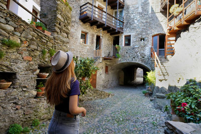 Tourism in lombardy italy. back view of beautiful girl visiting sondrio old town, valtellina, italy.