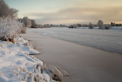 The river water is slowly freezing on a cold winter day at the rural finland. 