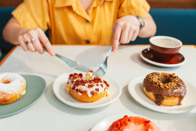 Midsection of woman eating food at restaurant
