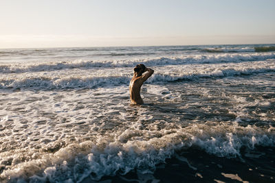 Man surfing in sea against sky