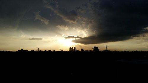 Silhouette cityscape against sky during sunset