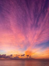 Scenic view of sea against dramatic sky during sunset