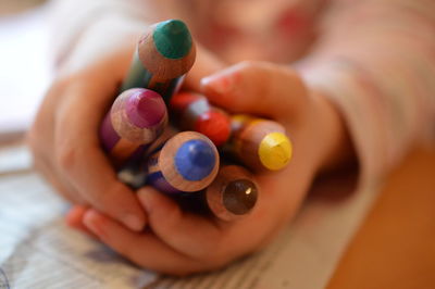 Close-up of kid holding colored pencils