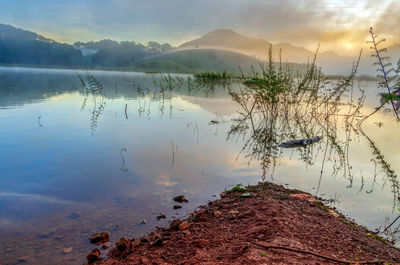 Scenic view of lake against sky at sunset