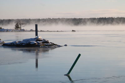 Scenic view of lake against sky during winter