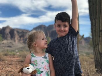 Portrait of happy boy with horse against sky