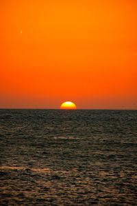 Scenic view of sea against orange sky