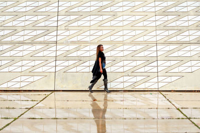 Full length of woman walking on tiled floor