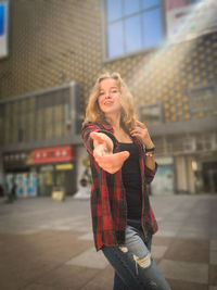 Portrait of smiling young woman standing in city