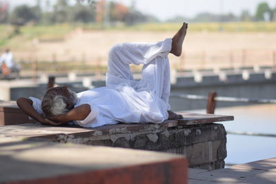 Rear view of man lying on water