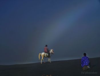 People riding motorcycle on land against sky