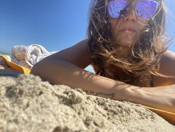 Low angle view of woman lying down against sky