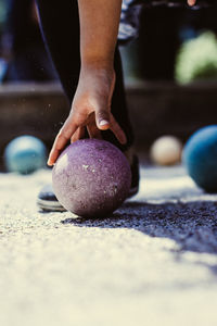 Low section of boy holding stone on footpath