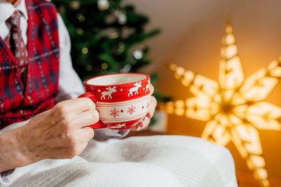 Midsection of woman holding coffee on table