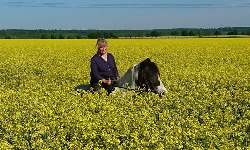 Rear view of woman with horse on field