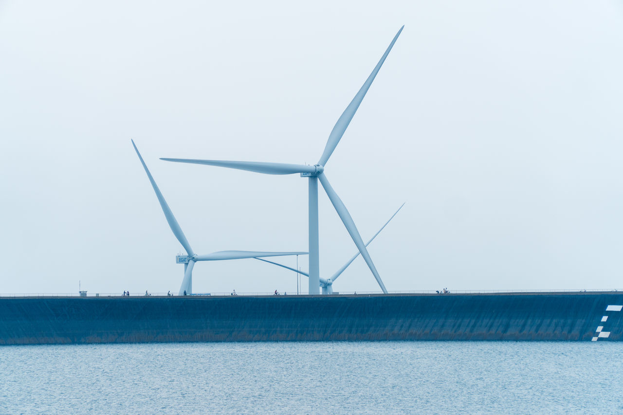 WINDMILLS ON LANDSCAPE AGAINST SKY