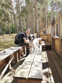 Man and dog on plants against trees