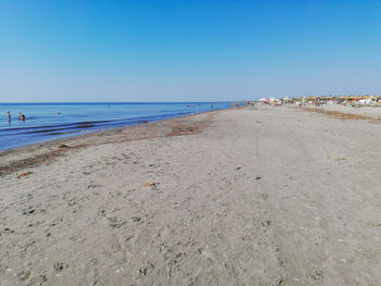 Scenic view of beach against clear blue sky