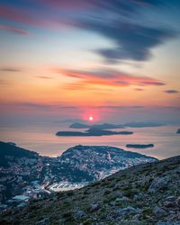 Townscape and sea against sky during sunset