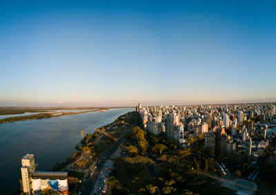 High angle view of buildings by sea against clear sky