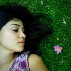 Close-up of beautiful woman relaxing on grass