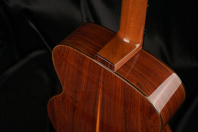 Close-up of acoustic guitar on bed