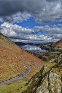 Scenic view of mountains by ullswater against cloudy sky