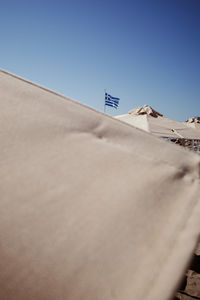 Low angle view of sand dune against clear blue sky