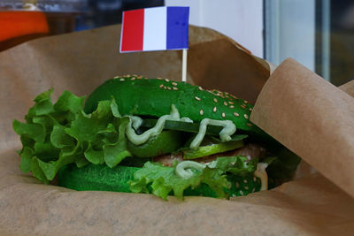 Close-up of green vegetarian burger with dutch flag on brown paper