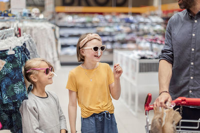 Smiling girls trying sunglasses in shop