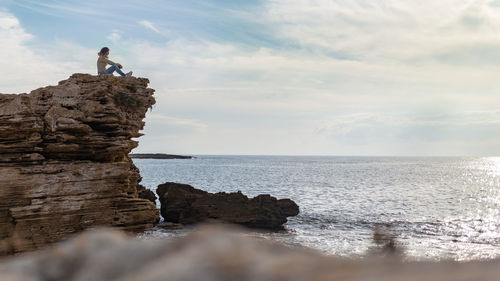 Scenic view of rock formation in sea against sky