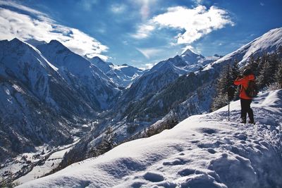 Rear view of person on snowcapped mountains against sky